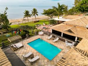 an overhead view of a swimming pool and the beach at Pousada Algodão da Praia in Araruama