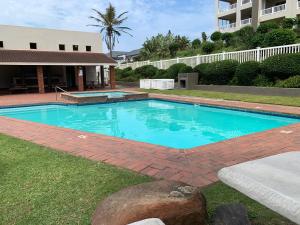 a swimming pool in a yard with a building at 125 Laguna La Crete, Uvongo in Margate