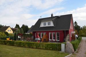 a red house with a black roof at Leuchtfeuer in Born