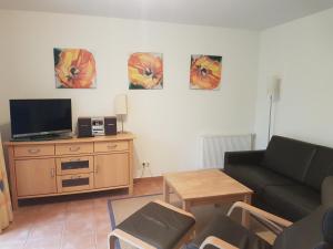 een woonkamer met een bank en een tv bij Residenz am Haferland in Wieck