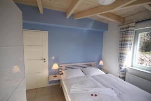 a bedroom with a large bed with blue walls and a window at Am Trommelplatz - Wolke 7 in Wieck