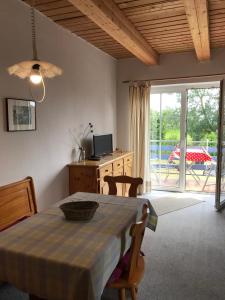 a dining room with a table and a sliding glass door at Pension Martens - Lotte in Wieck