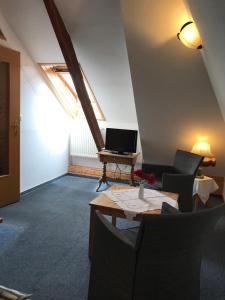 a living room with a table and a laptop on a desk at Pension Martens - Lotte in Wieck
