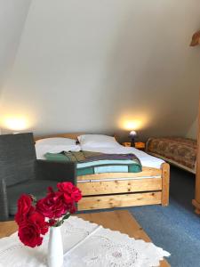 um quarto com uma cama e um vaso de rosas sobre uma mesa em Pension Martens - Lotte em Wieck