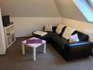 a living room with a black couch and a table at Graureiher in Wieck