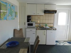 a small kitchen with a table and a microwave at Haus Krüger in Wieck