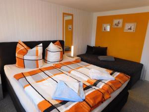 a bedroom with a large bed with pillows and a couch at Haus Krüger in Wieck