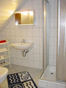 a white bathroom with a sink and a shower at Pension Martens - Gaubenwohnung in Wieck
