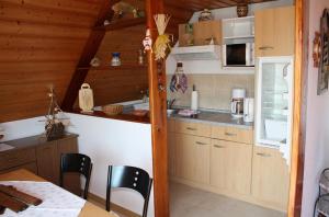a kitchen with wooden cabinets and a table and chairs at Große Fewo 1 in Jagdhaus