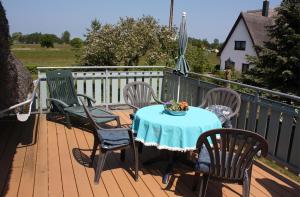 a table and chairs on a wooden deck at Große Fewo 1 in Jagdhaus