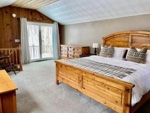 um quarto com uma cama de madeira e uma grande janela em Mandy's Mountain Chalet em Dover