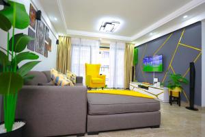 a living room with a couch and a yellow chair at Elite Luxury Apartments Kilimani - An Oasis of Serenity and Tranquility in Nairobi