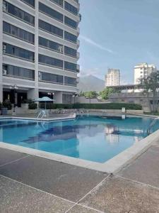 una gran piscina frente a un edificio en Ritasol Palace apartamento de relax frente al mar, en Caraballeda