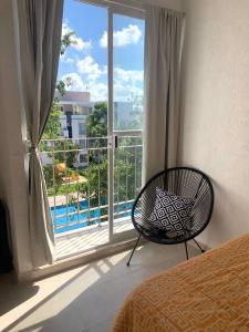 a bedroom with a window with a view of a pool at Departamento 2 habitaciones vista a la alberca Nube by EITA in Cancún