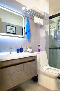 y baño con aseo, lavabo y espejo. en Elite Luxury Apartments Kilimani - An Oasis of Serenity and Tranquility, en Nairobi