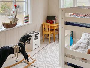 Holiday home HANINGE II في هانينيه: غرفة نوم مع كلب يقف على مكنسة