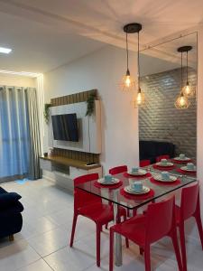 - un salon avec une table et des chaises rouges dans l'établissement Muro Alto Condominio Clube Apt.111 térreo, à Porto de Galinhas