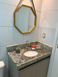 La salle de bains est pourvue d'un lavabo et d'un miroir. dans l'établissement Muro Alto Condominio Clube Apt.111 térreo, à Porto de Galinhas