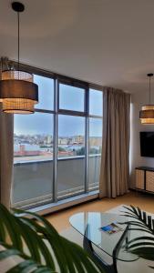 ein Wohnzimmer mit einem großen Fenster und einem Glastisch in der Unterkunft Apartment T1 - Porto in Porto