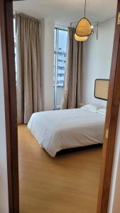 Schlafzimmer mit einem Bett und einem Fenster in der Unterkunft Apartment T1 - Porto in Porto