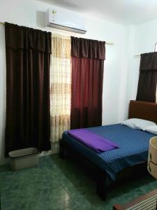Schlafzimmer mit einem Bett und einem Fenster mit Vorhängen in der Unterkunft EMMA HOUSE in Puerto Baquerizo Moreno