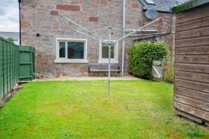 a yard with a bench in front of a house at Central 2 bedroom luxury home close to River Ness in Inverness