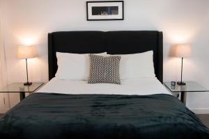 a bedroom with a large bed with two lamps at Central 2 bedroom luxury home close to River Ness in Inverness