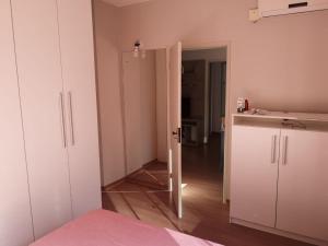 Habitación con armarios blancos y puerta a la cocina en Ensolarado e espaçoso quarto/sala no coração de POA, en Porto Alegre