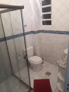 Baño blanco con aseo y lavamanos en Ensolarado e espaçoso quarto/sala no coração de POA, en Porto Alegre