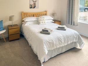 a bedroom with a white bed with towels on it at Dalnafeidh Beag in Portnacroish