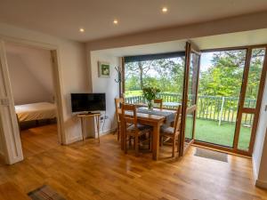 une salle à manger avec une table, des chaises et une télévision dans l'établissement Ledi, à Linlithgow