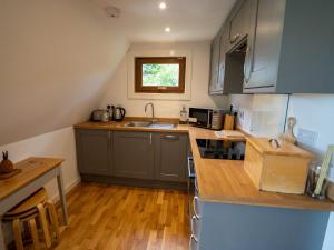 a kitchen with gray cabinets and a wooden floor at Ledi in Linlithgow