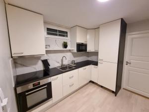a white kitchen with white cabinets and a sink at Chausseen Apartment 