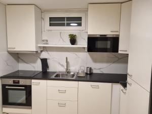 a kitchen with white cabinets and a sink at Chausseen Apartment 