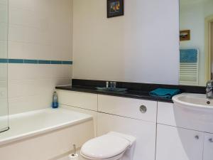 a white bathroom with a toilet and a sink at Lime Court in Leatherhead