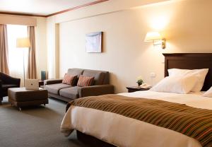 Habitación de hotel con cama y sofá en Hotel Presidente Huancayo - Asociado Casa Andina, en Huancayo