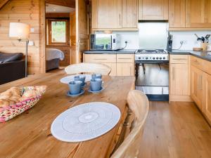 una pequeña cocina con una mesa de madera en una cabaña en Tunturi, en Linlithgow