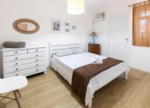 1 dormitorio con cama, tocador y espejo en Loft Califórnia, en Bombinhas