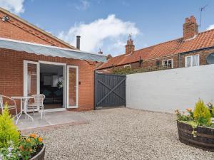 a brick house with a gate and a patio at Cozy Lodge in Barton-upon-Humber