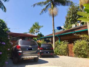 two cars parked in front of a house at Chalés Água Grande in Maresias