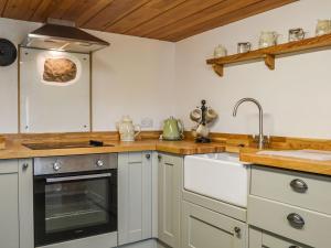 a kitchen with a sink and a stove at The Bothy in Dearham