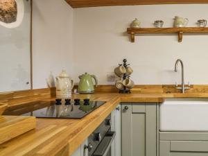 a kitchen with wooden counter tops and a sink at The Bothy in Dearham
