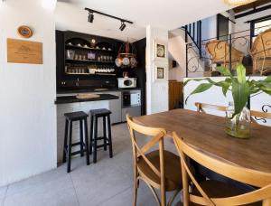 cocina y comedor con mesa de madera y sillas en Loft Califórnia, en Bombinhas