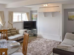 a living room with a couch and a table at Tracara Cottage in Horning