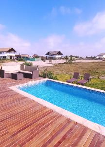 una piscina con terraza de madera junto a una playa en CASA LUNA, en Chincha Baja