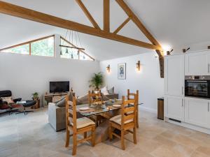 a kitchen and living room with a table and chairs at North Farm Lodge in East Mersea