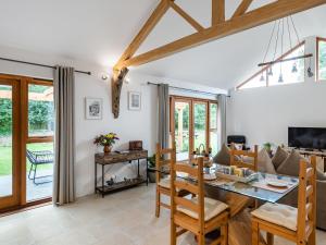 a dining room and living room with a table and chairs at North Farm Lodge in East Mersea