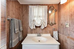 a bathroom with a sink and a window at Shipwrecked Shack Waterfront House Boat on Land in Sealevel +24 photos