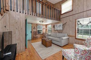 a living room with a couch and a table at Shipwrecked Shack Waterfront House Boat on Land in Sealevel