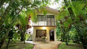 uma casa no meio de uma floresta com palmeiras em Orquideas Boutique Hotel em La Fortuna